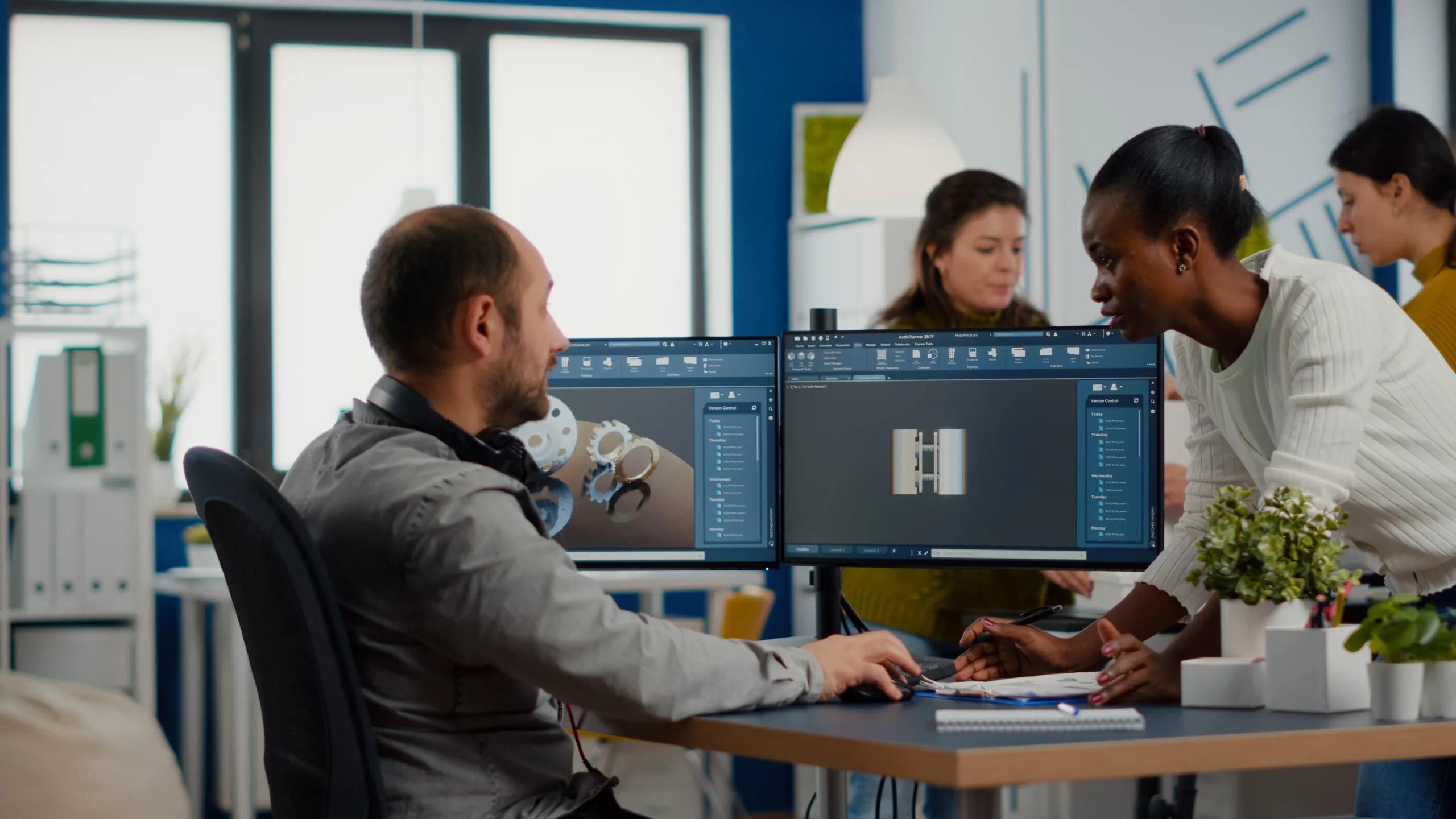 BIM specialists analysing mechanical metallic parts using BIM software.