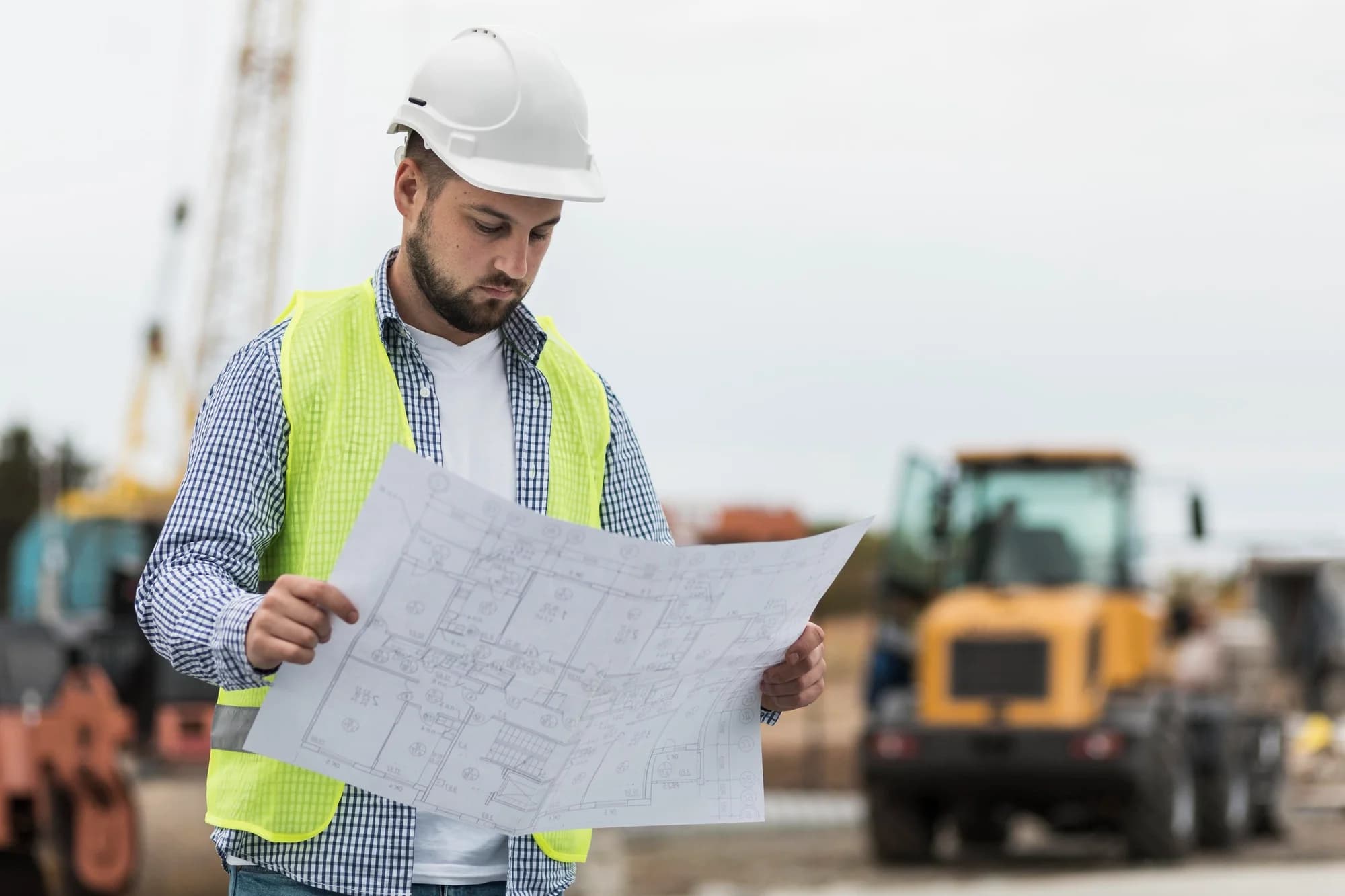 Civil Engineer analysing blueprint onsite.
